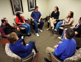 A room full of people doing Group therapy